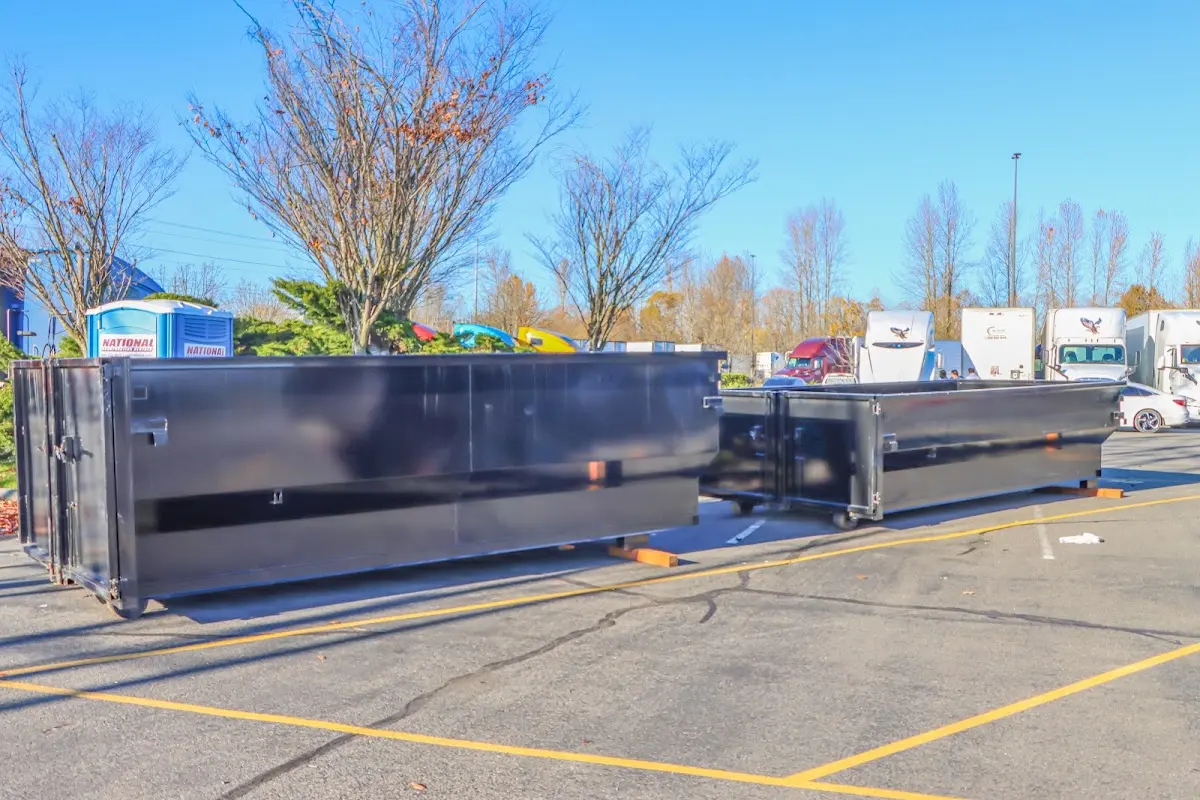 Professional dumpster rental service with roll-off container on residential driveway in French Valley